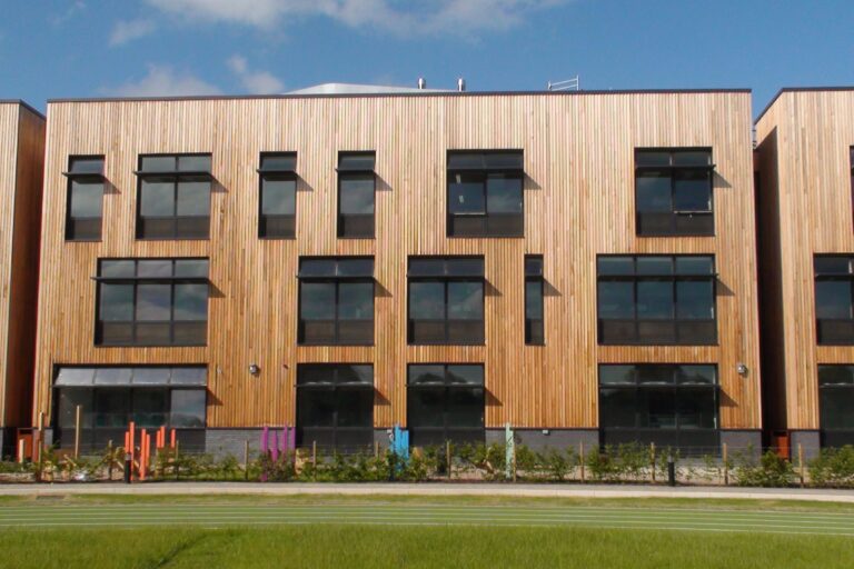 Building with timber cladding, and windows with integrated natural ventilation
