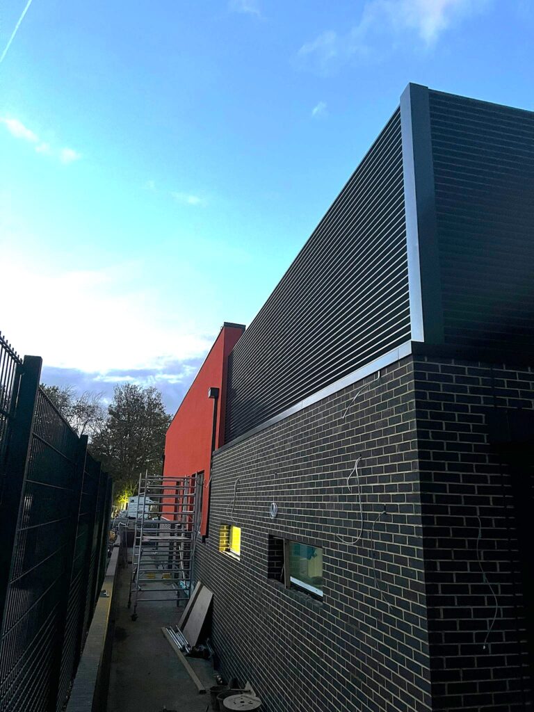 Gallery 99 aluminium louvre on top of a brick wall